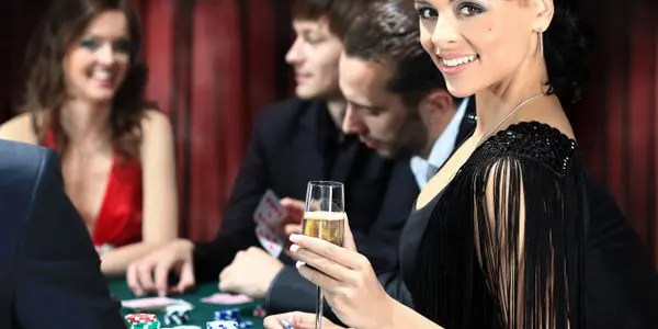 A woman holding a glass of champagne at a casino.