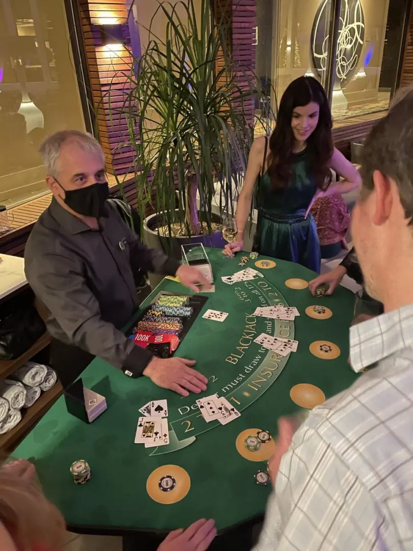 A group of people playing blackjack at a casino.