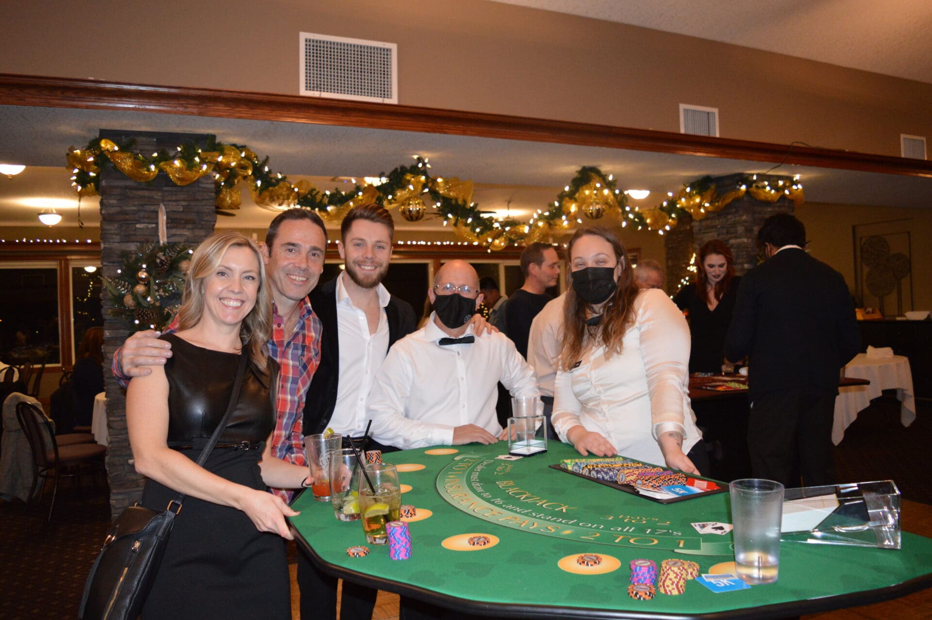 A group of people standing around a table with a casino theme.