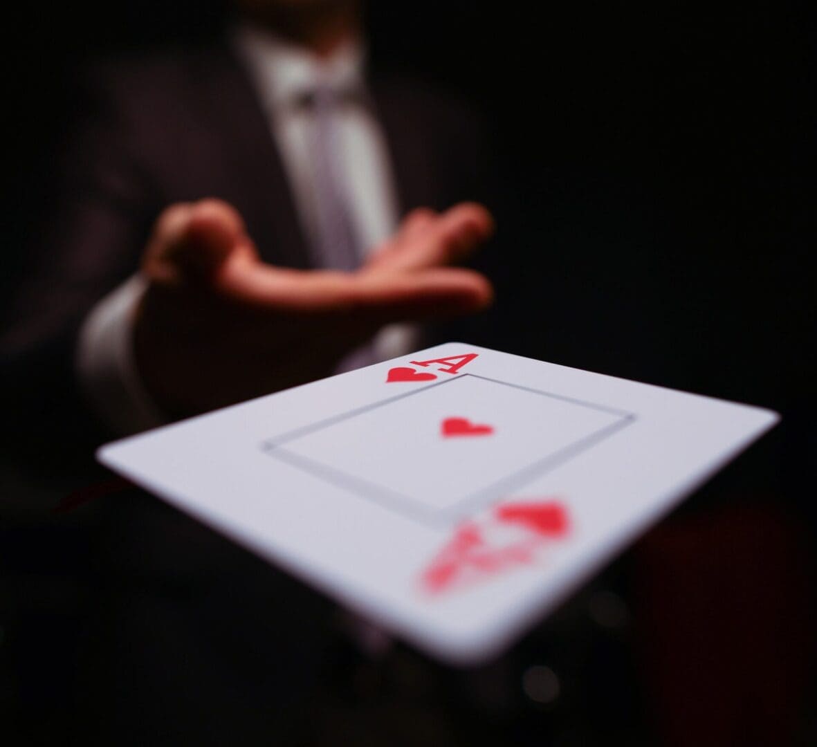 A man in a suit and tie holding out two cards.