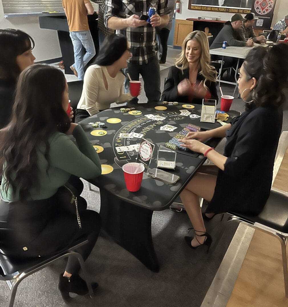 A group of people sitting around a table playing cards.