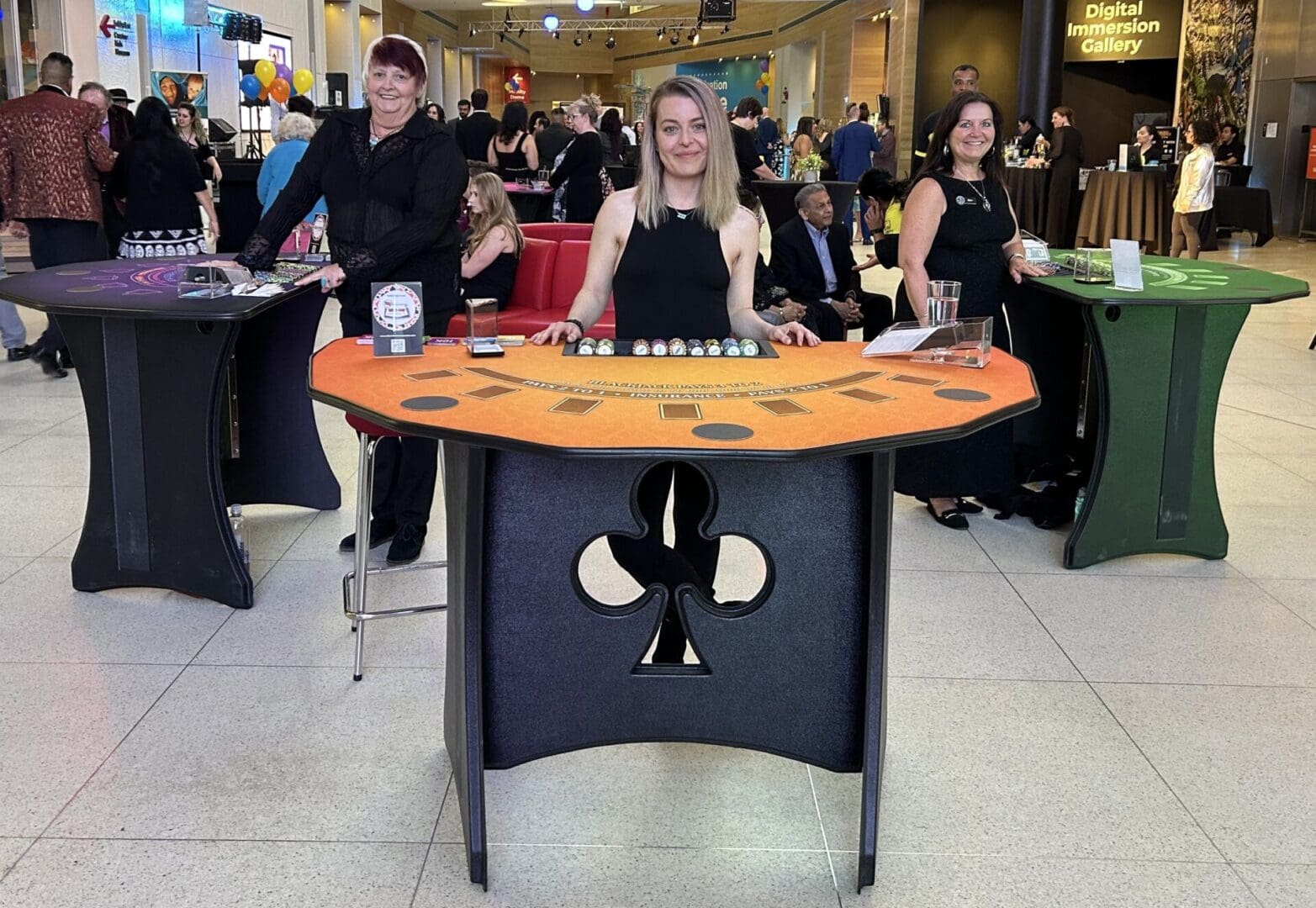A woman standing behind a table with a black and orange design.